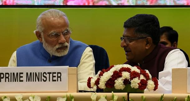 Indian Prime Minister Narendra Modi (L) talks with Minister of Communication and IT Ravi Shankar Prasad during the launch the National Agriculture Market, an e-market platform at Vigyan Bhawan in New Delhi on April 14, 2016. (Photo credit: MONEY SHARMA/AFP/Getty Images)